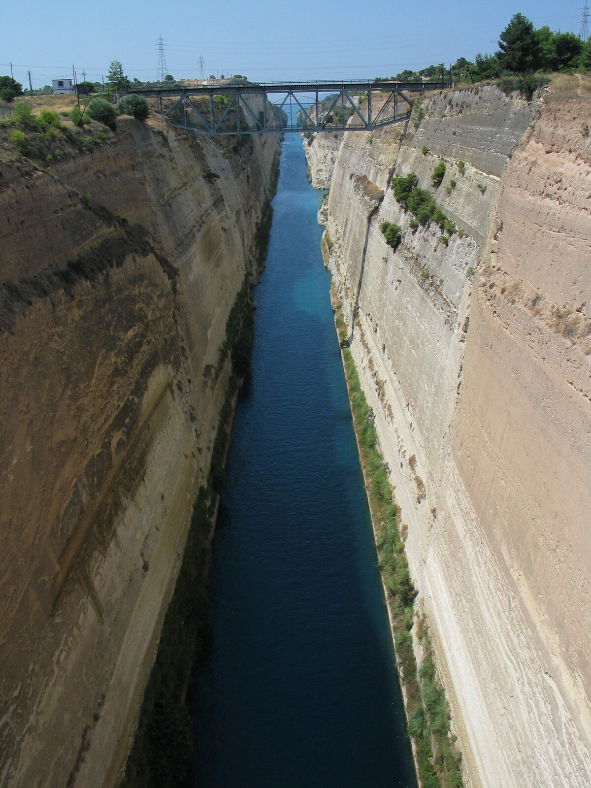 Narrow limestone-walled Corinth Canal seen from the road bridge crossing it in Greece