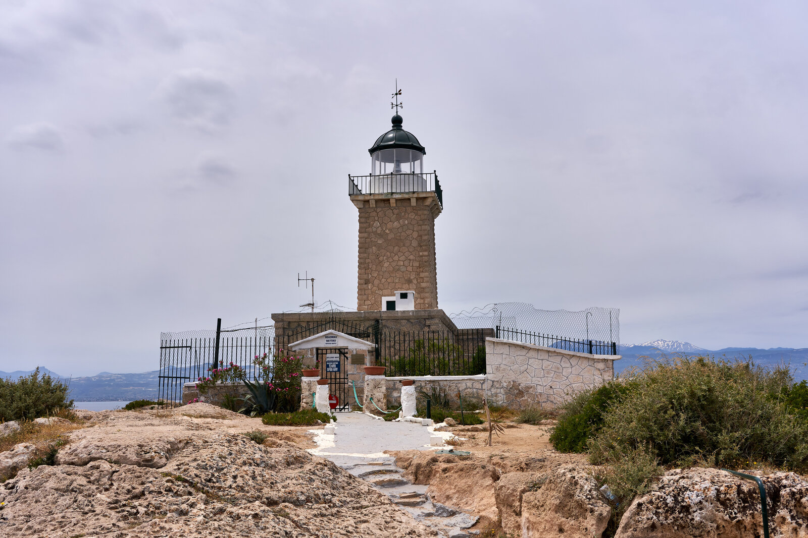 The Melagavi lighthouse standing on rocks at the tip of the Perachora peninsula
